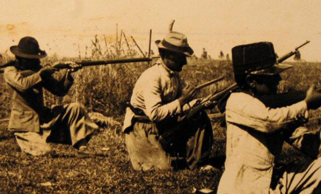 Fotografía de tres soldados apuntando con un arma.
