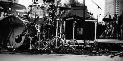 Fotografía en blanco y negro de equipos e instrumentos al costado de un gran escenario.