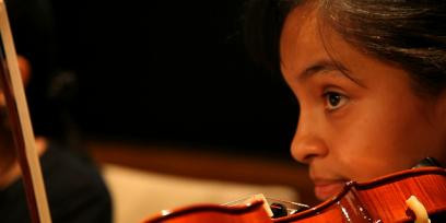Primer plano de una niña tocando el violín.