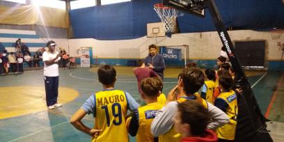 Profesor explicandole a alumnos sobre lanzamiento en Básquetbol.