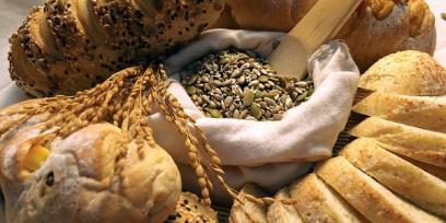 Imagen de diferentes alimentos que aportan carbohidratos: pan, granos, etc.