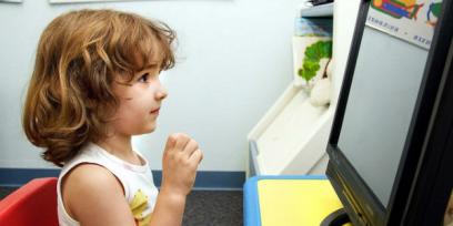 Fotografía de una niña enfrentada a un monitor.