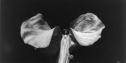 Loie Fuller en su danza serpentina, moviendo sus brazos desplazando telas