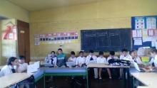 Alumnos de sexto año en clase usando laptops