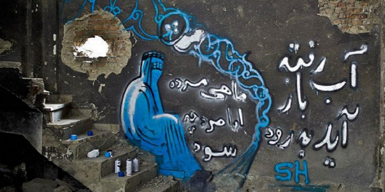 Fotografía de un muro graffiteado, se aprecia una mujer con su burka en tonos de azul y un texto en árabe. Aparecen los aerosoles usados, una escalera de cemento
