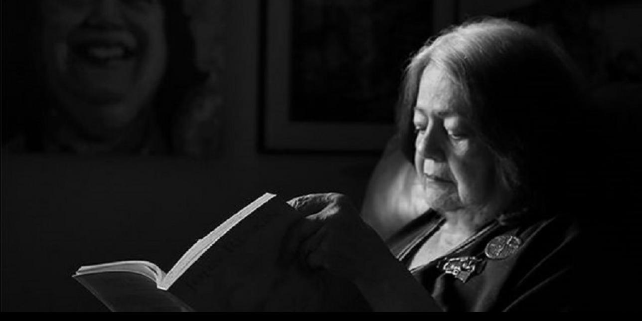 Imagen de Ana Mae Barboza sentada leyendo un libro.