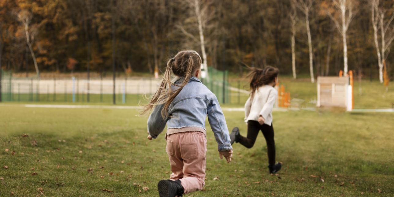 Niños corriendo en un parque agreste.