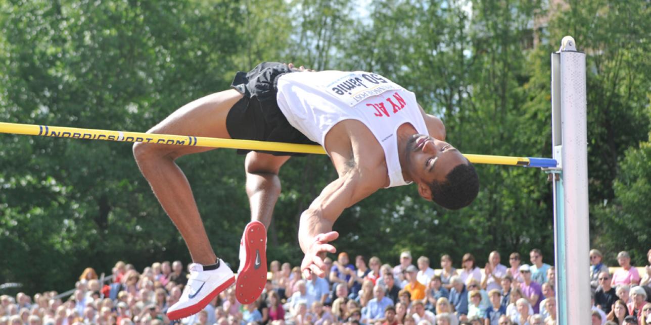 Imagen de un atleta en fase de vuelo del salto sobre un obstáculo.