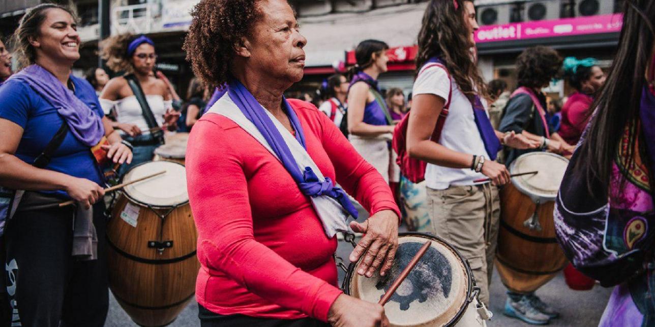 Comparsa de mujeres "Melaza", varias mujeres caminando y tocando el tambor por la calle.