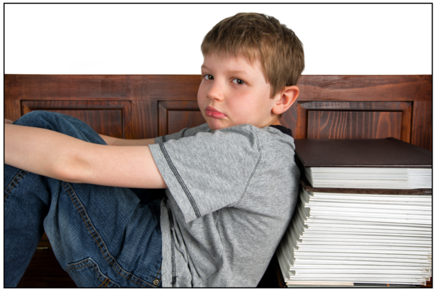 Niño triste apoyado en libros