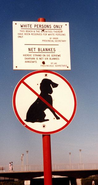 Dos carteles en una playa de Ciudad del Cabo en 1985: el letrero en ingl&eacute;s y en afrikaans dice que el acceso a la playa y sus instalaciones s&oacute;lo es permitido a los blancos, el cartel inferior proh&iacute;be el ingreso de perros a la playa.