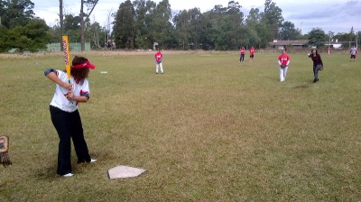 La exembajadora Julissa Reynoso se aporonta para intentar batear un lanzamiento de la pitcher
