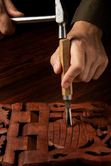 Mano esculpiendo una obra en madera