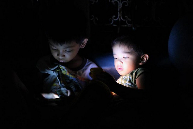 niños en la noche, sin dormir miran pantallas de celulares en solitario