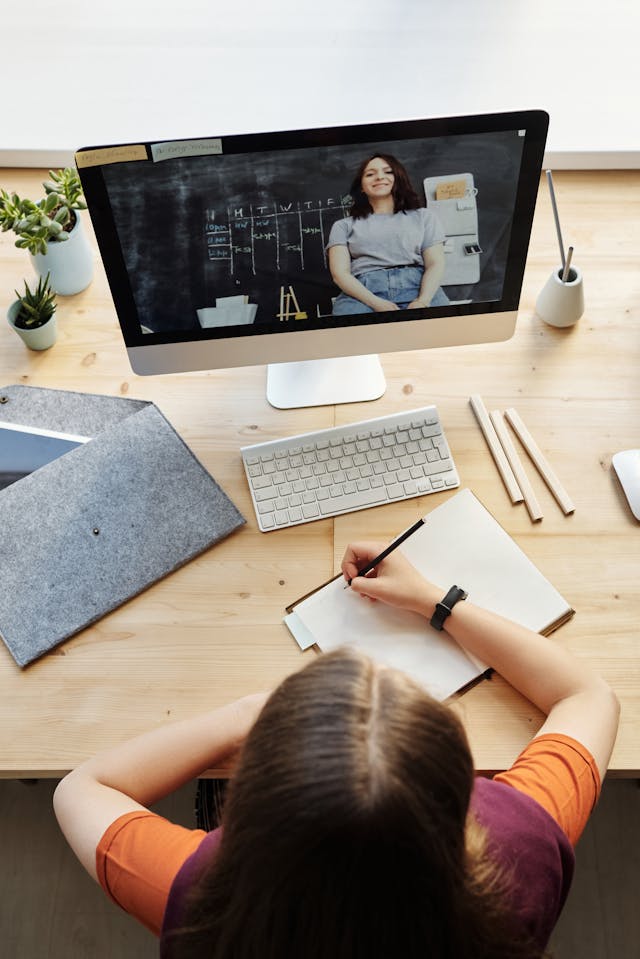Persona trabajando en un escritorio frente a una computadora
