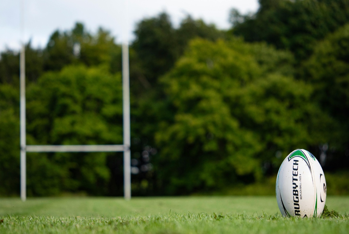 Pelota de rugby dispuesta de forma vertical pronta como para patear hacia los palos de la H