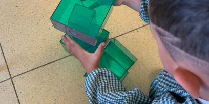 Niño jugando agrupando cuerpos geométricos