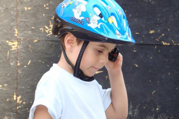 Niño con casco protector hablando por celular.