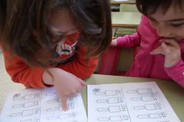 Fotograma del video en que aparecen dos niños haciendo revisión de pares