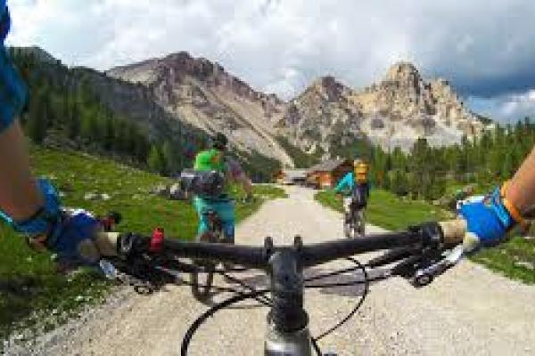 Ciclista subiendo cordillera con paisaje de montañas.