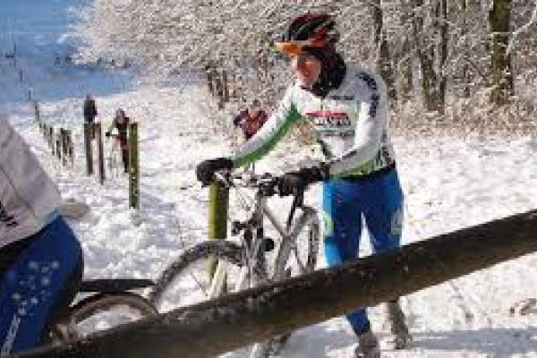 Ciclistas subiendo cima en ambiente frío y nevando.