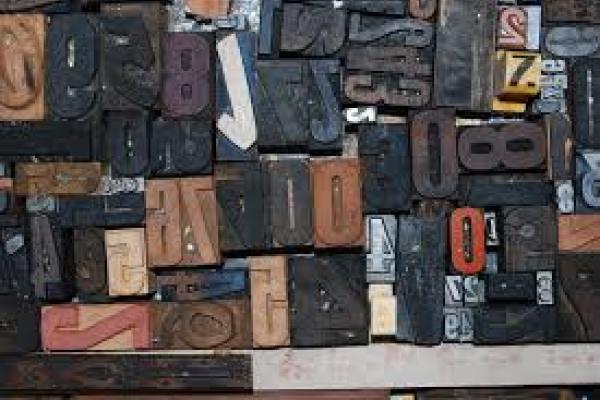 La imagen muestra letras y números hechos en madera