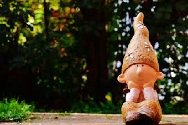 Imagen que muestra una representación de un duende de jardín en un contexto de vegetación