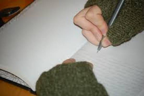 Imagen que muestra las manos de una persona escribiendo sobre un cuaderno