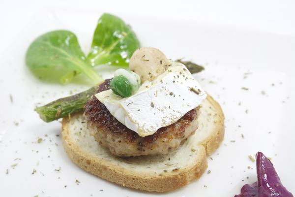 Imagen que muestra una preparación comestible y decorada, que incluye verduras, pan, queso