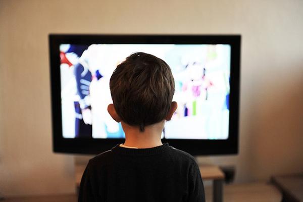 Fotografía de niño mirando la televisión. 