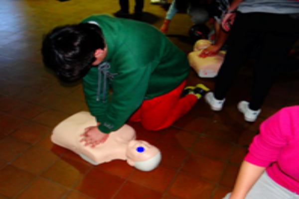 Joven realizando práctica de resucitación cardíaca básica.