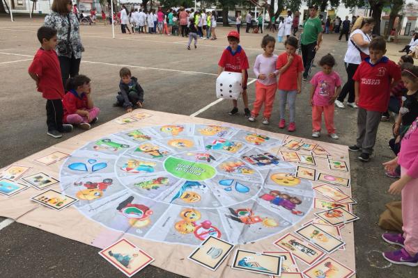 Niños en juego interactivo grande en plaza de deportes.