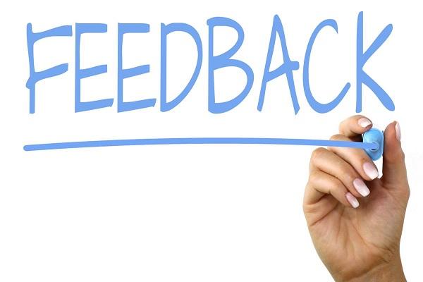 Mano escribiendo en un pizarrón la palabra feedback (en inglés) que significa retroalimentación
