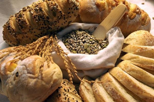 Imagen de diferentes alimentos que aportan carbohidratos: pan, granos, etc.