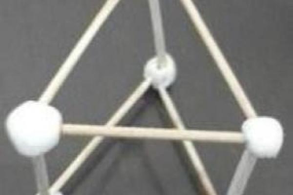 Representación de un prisma de base triangular con pajitas y bolitas