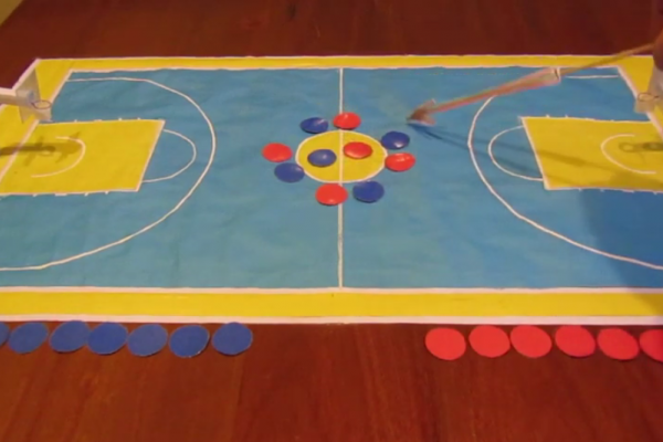 Cancha de básquetbol en cartón con jugadores de ambos equipos para expliczarel reglamento.