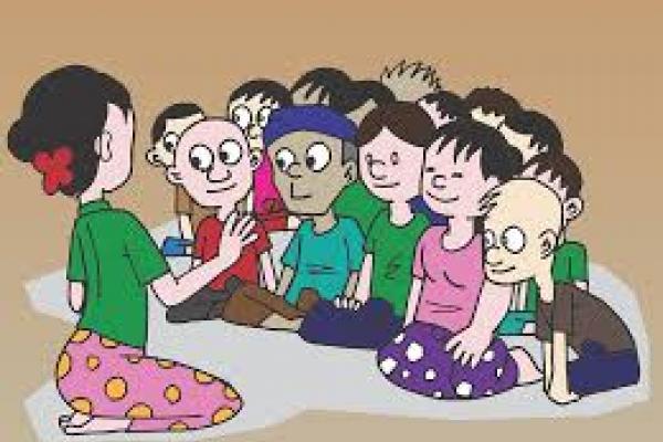 Profesora dando clase a adolescentes sentados en el piso.