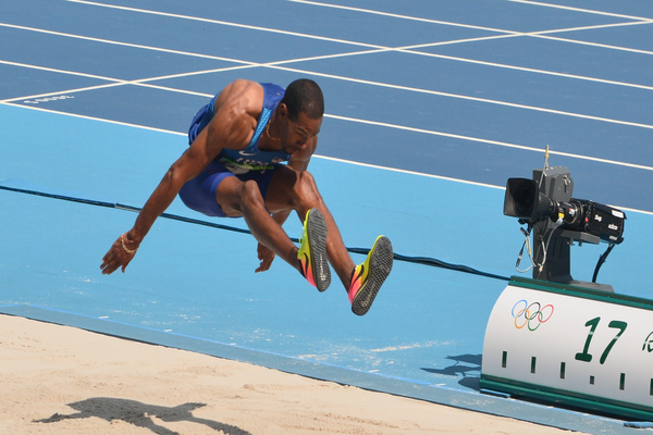 Atleta realizando salto triple.