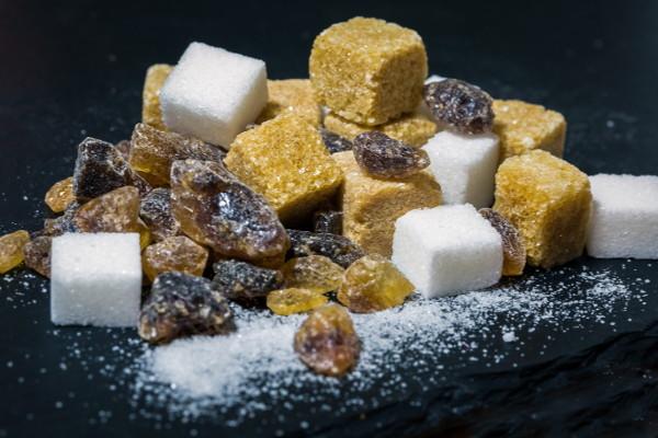 Conjunto de terrones de azúcar blanca y rubia, con pasas de uva.