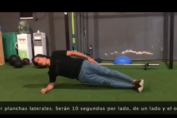 Atleta realizando plancha lateral.