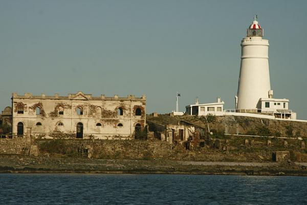 Imagen actual de la Isla de Flores con vista al faro y restos del Lazareto