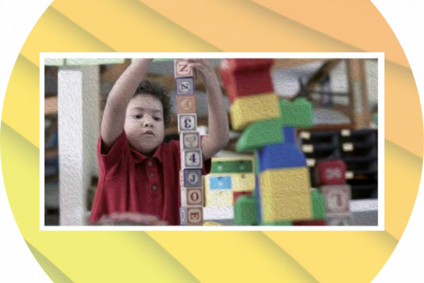 Niño construyendo una torre con cubos con letras.