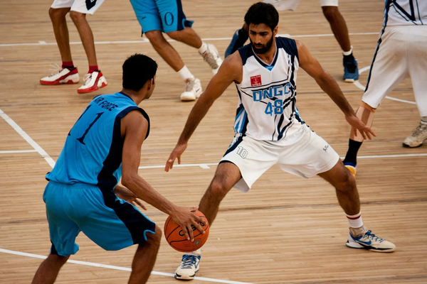 Jugadores de básquetbol en plena acción de partido.