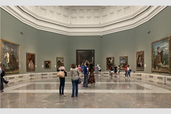 Imagen de una sala del Museo del Prado, con público apreciando las obras de arte expuestas.