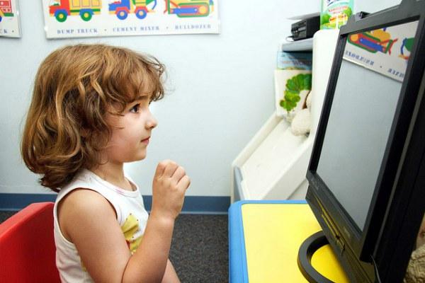 Fotografía de una niña enfrentada a un monitor.