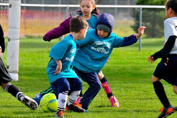 Niños y niñas jugando fútbol