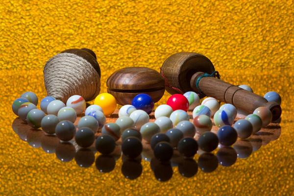 Se muestra un conjunto de bolitas, trompo, balero y yo-yo