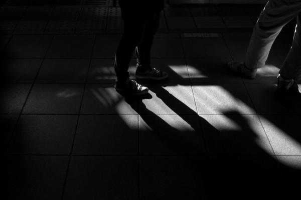 Imagen de piernas junto a sus sombras en blanco y negro 