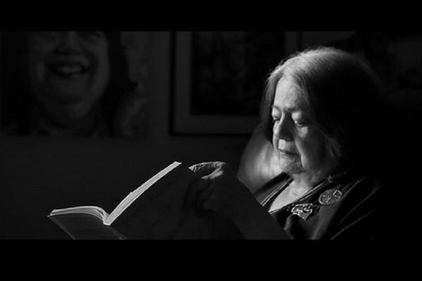 Imagen de Ana Mae Barboza sentada leyendo un libro.