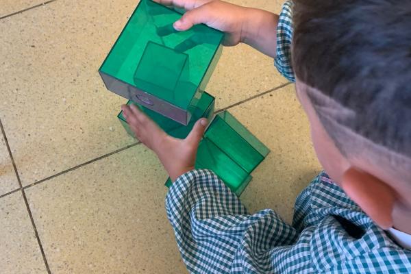 Niño jugando agrupando cuerpos geométricos
